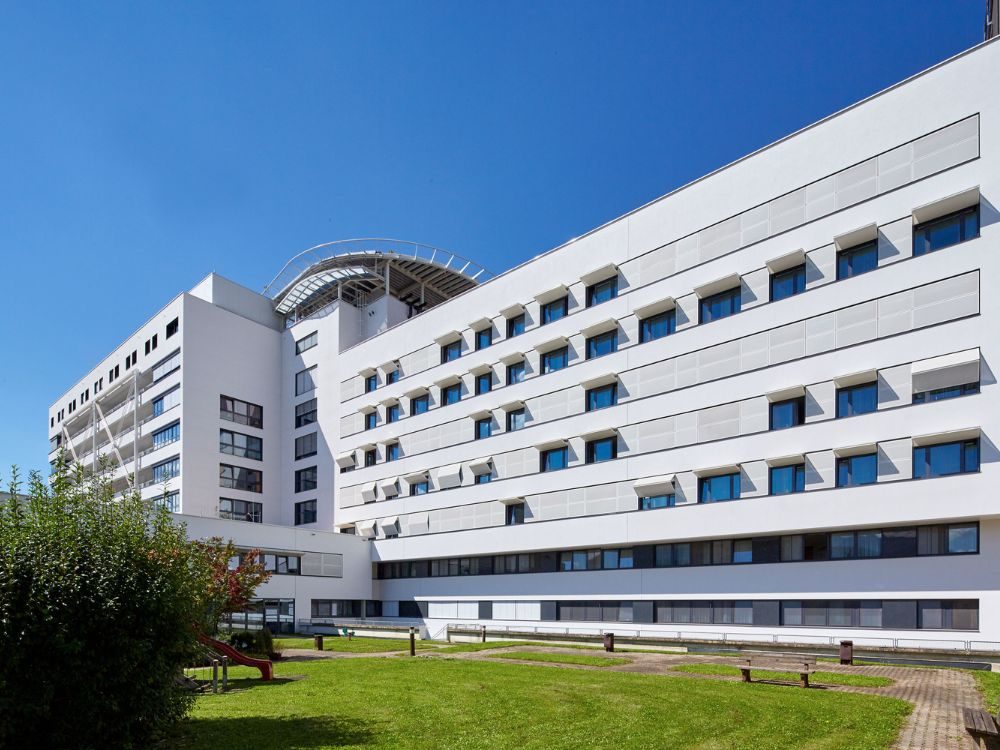 LKH Leoben mit Fassadengestaltung aus Lochblech: Sonnenschutz in Form von funktionalen Faltschiebeläden